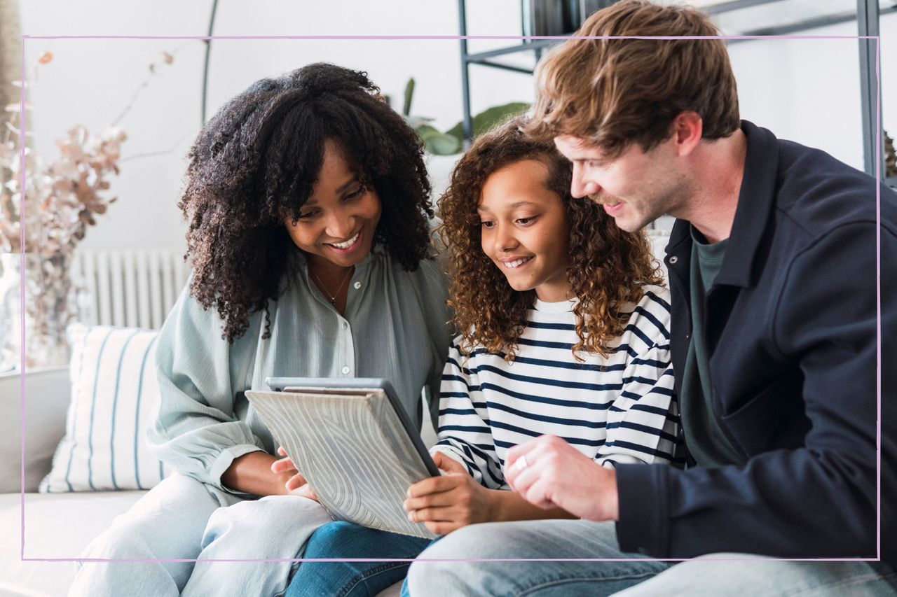 Family smiling while they look at school report with daughter