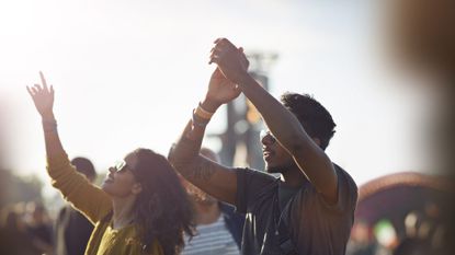 friends with arms in the air at festival concert