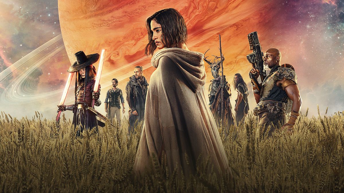 A screenshot of the official poster for Rebel Moon Part One: A Child of Fire, which shows the main cast standing in a field of wheat