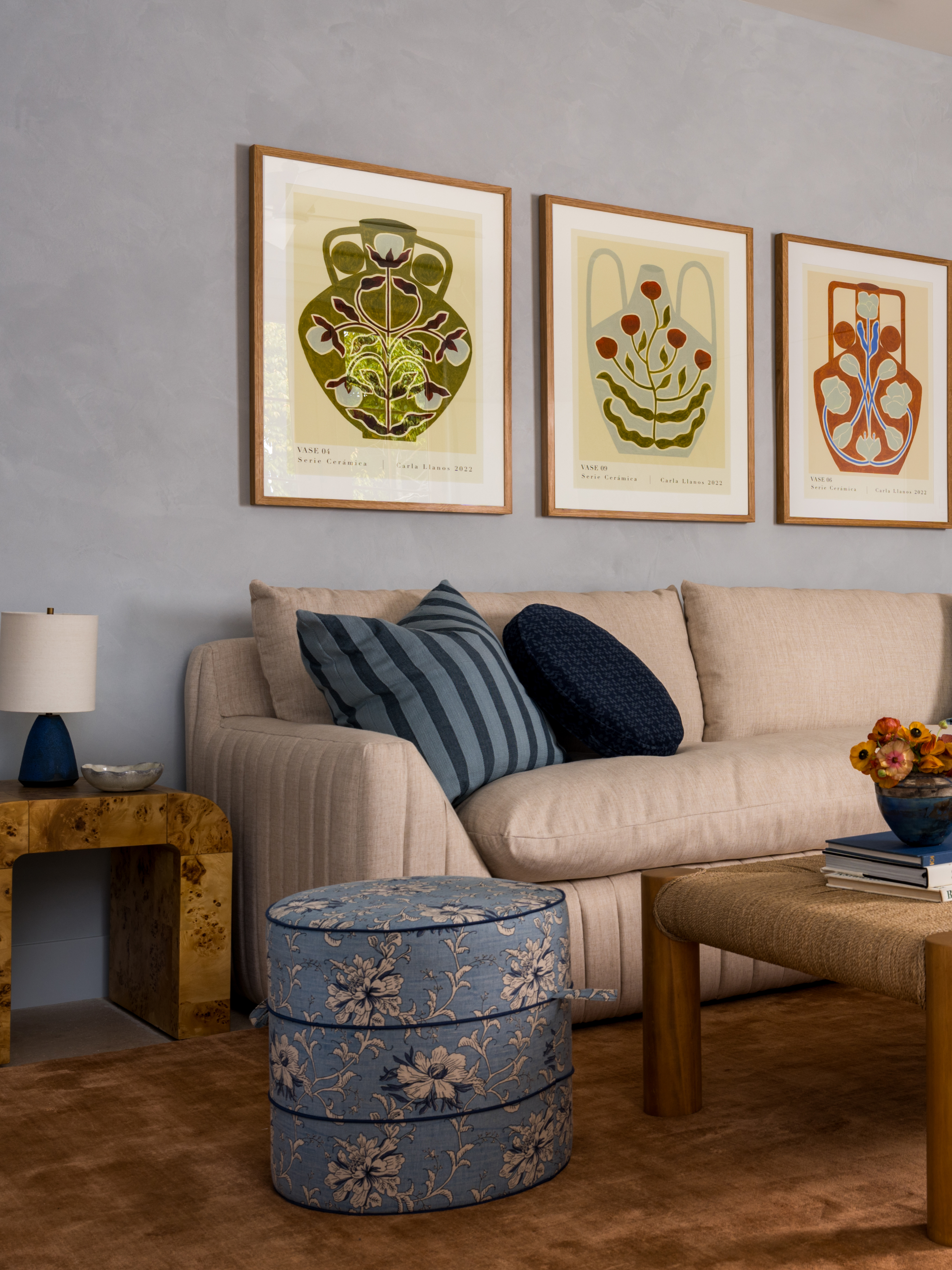 Room with powder blue walls side table and beige sofa and blue upholstered pouf
