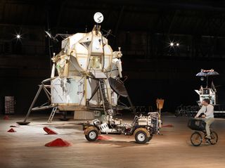Installation view of the Landing Excursion Module (LEM), Mars Excursion Roving Vehicle (MERV), and Tom Sachs on WAR Bike in "Space Program: Mars."