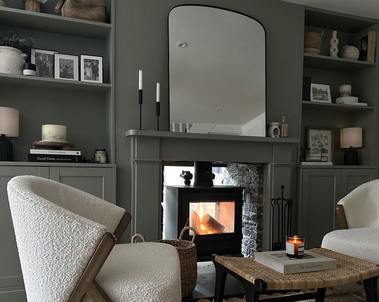 A living room with built-in alcove shelving painted green