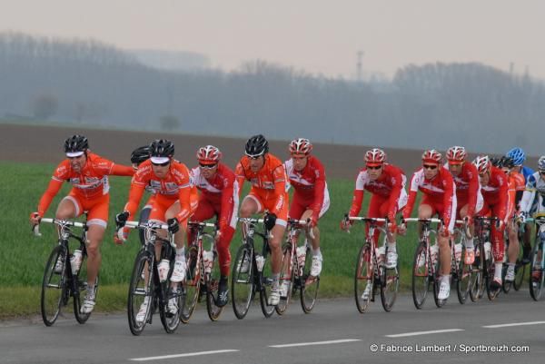 The front of the bunch awash in red and orange as Roubaix Lille Metropole and Cofidis work the chase