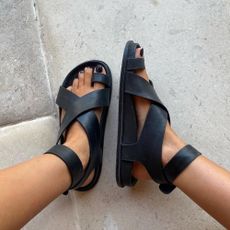 Woman wears black leather sandals 