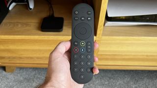 Sky Stream remote held in a man's hand