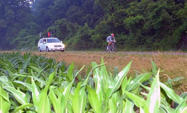 Mike Janelle rides past fields of young corn