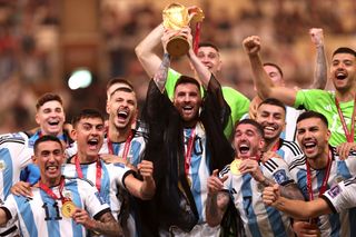 Lionel Messi lifts the World Cup trophy as Argentina's players celebrate victory in the final against France in Qatar in December 2022.