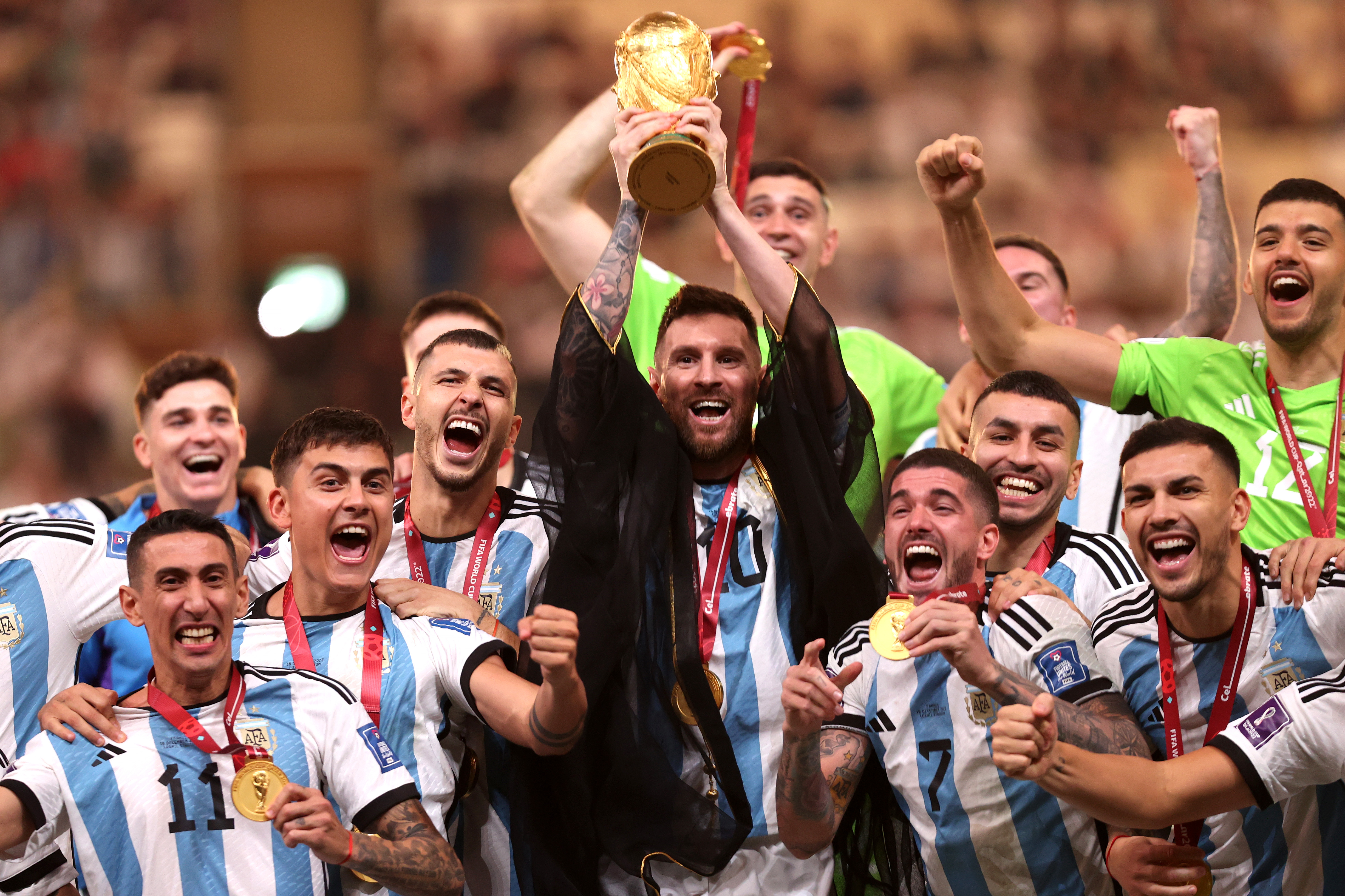 Lionel Messi lifts the World Cup trophy as Argentina's players celebrate victory in the final against France in Qatar in December 2022.