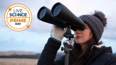woman using astronomy binoculars on a tripod