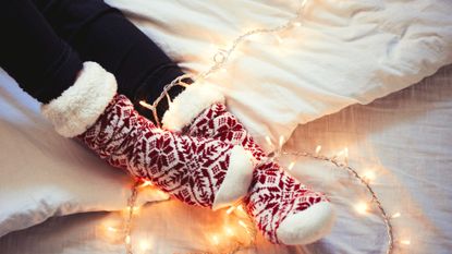 Young woman wearing fuzzy socks in her home in Christmas time