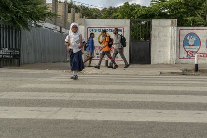 A girl crosses the street in Dar es Salaam.