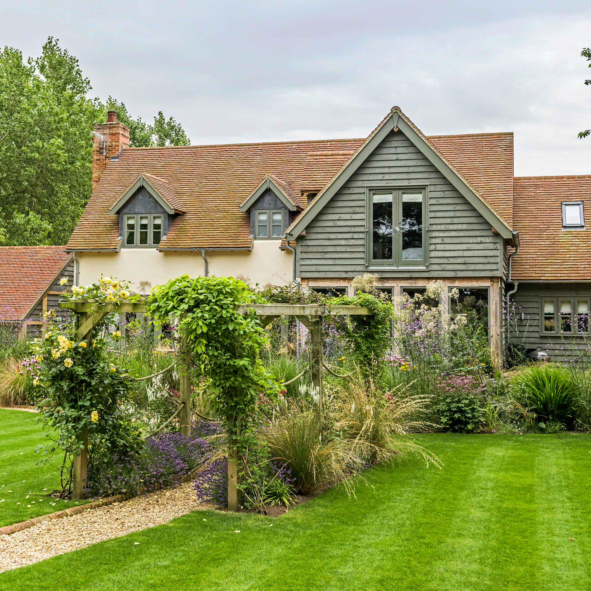 Green house with pergola covered in flowers