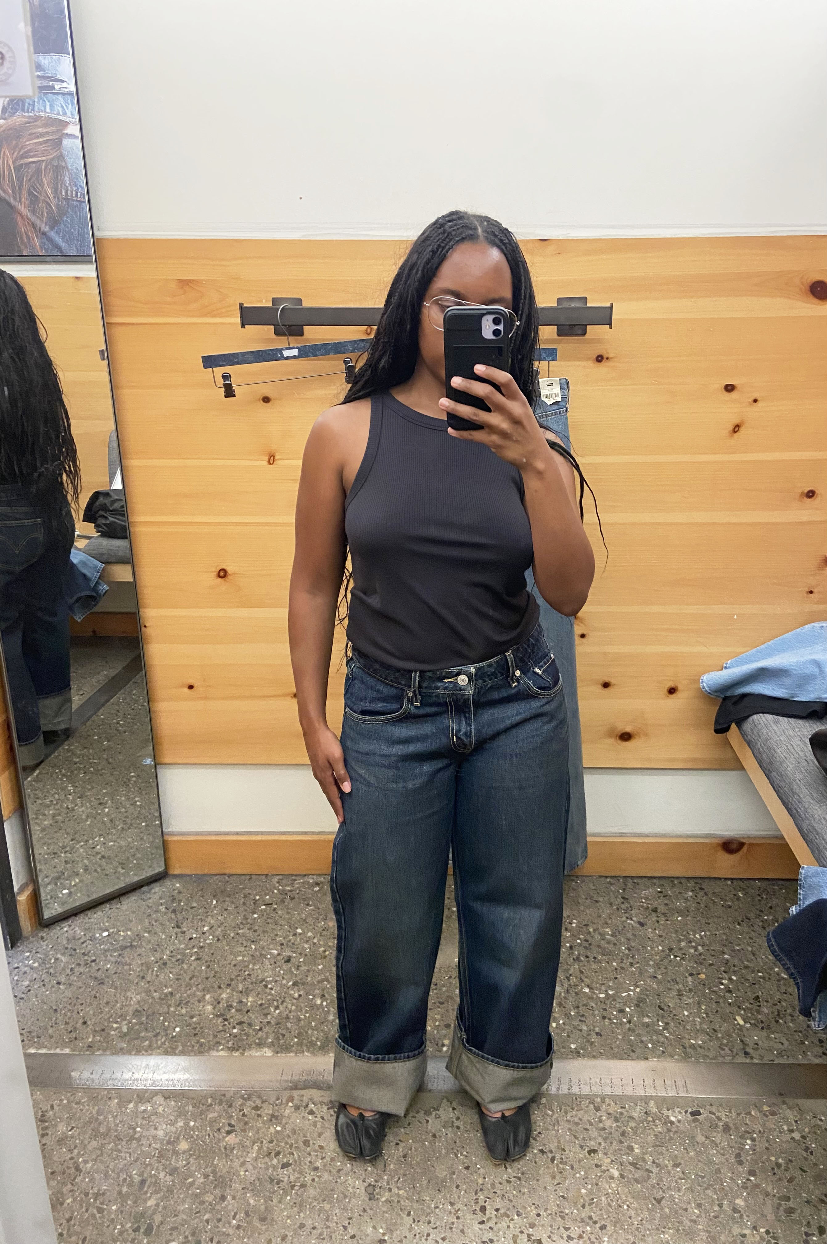 a woman wearing jeans and a black tank top