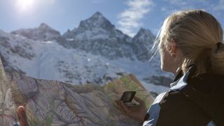 Hiker looking at map and distant mountain peaks