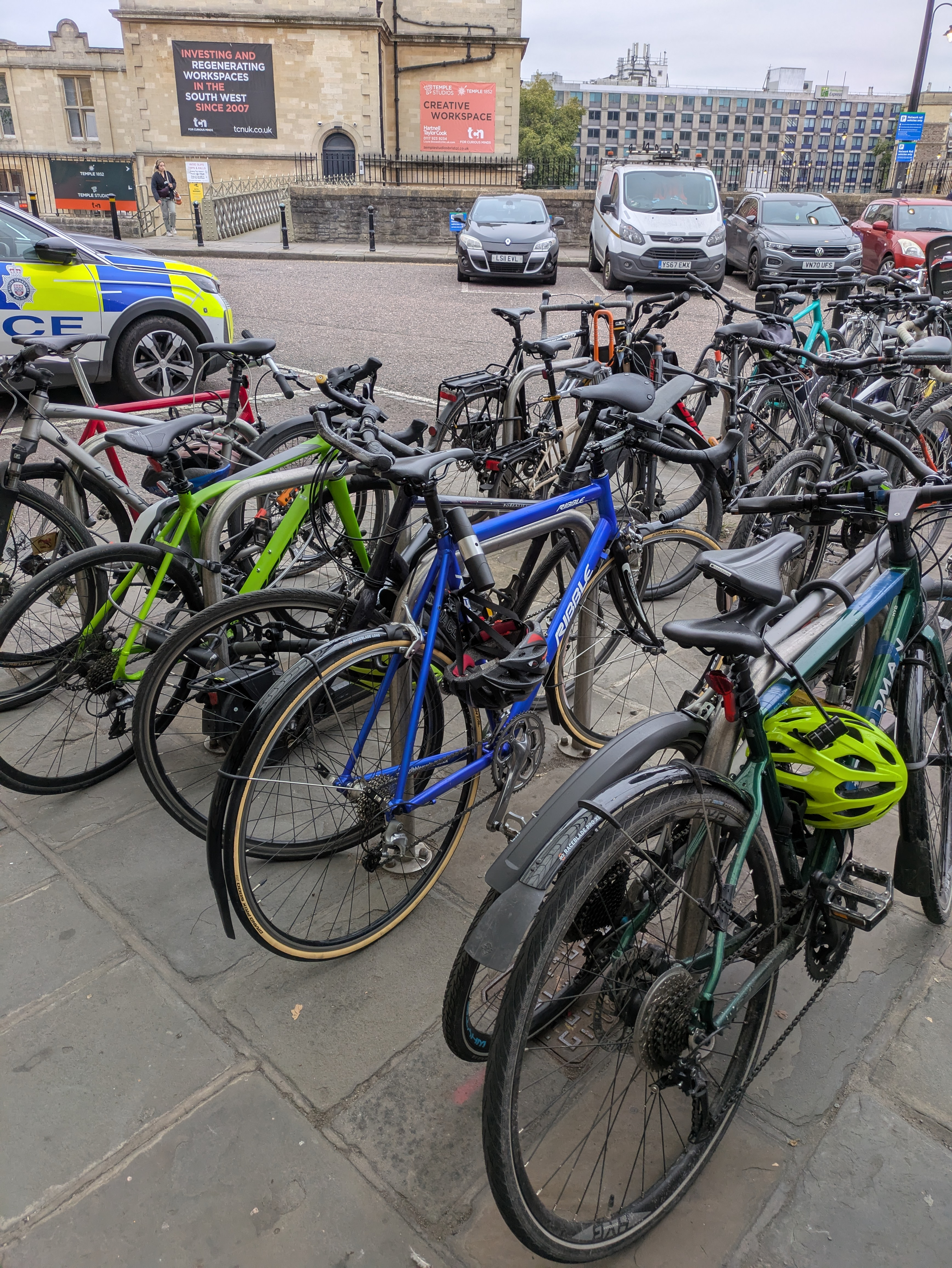 A blue Ribble audax bike locked up at a train station