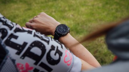 Female cyclist wearing a smartwatch which is tracking her heart rate