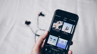 A photo of the spotify mobile app on an iphone in someone's hand