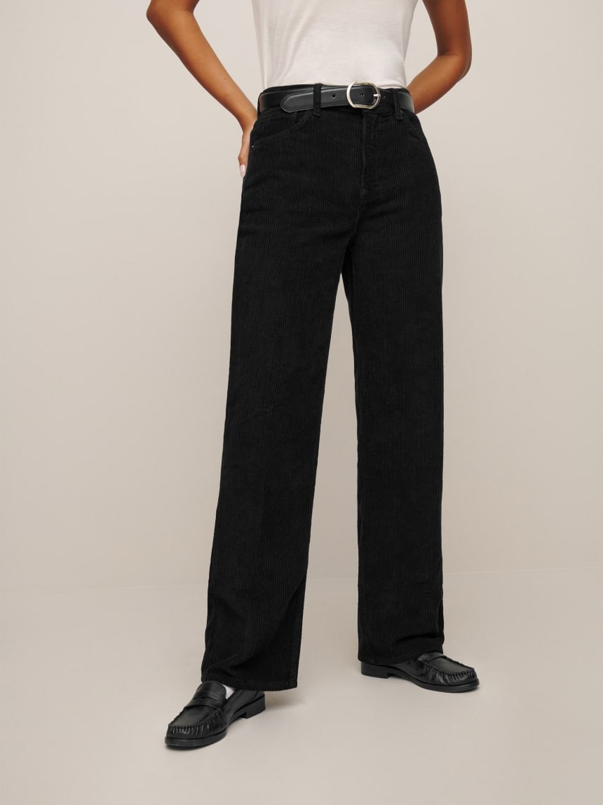 close up shot of Reformation model wearing black corduroy pants and black loafers