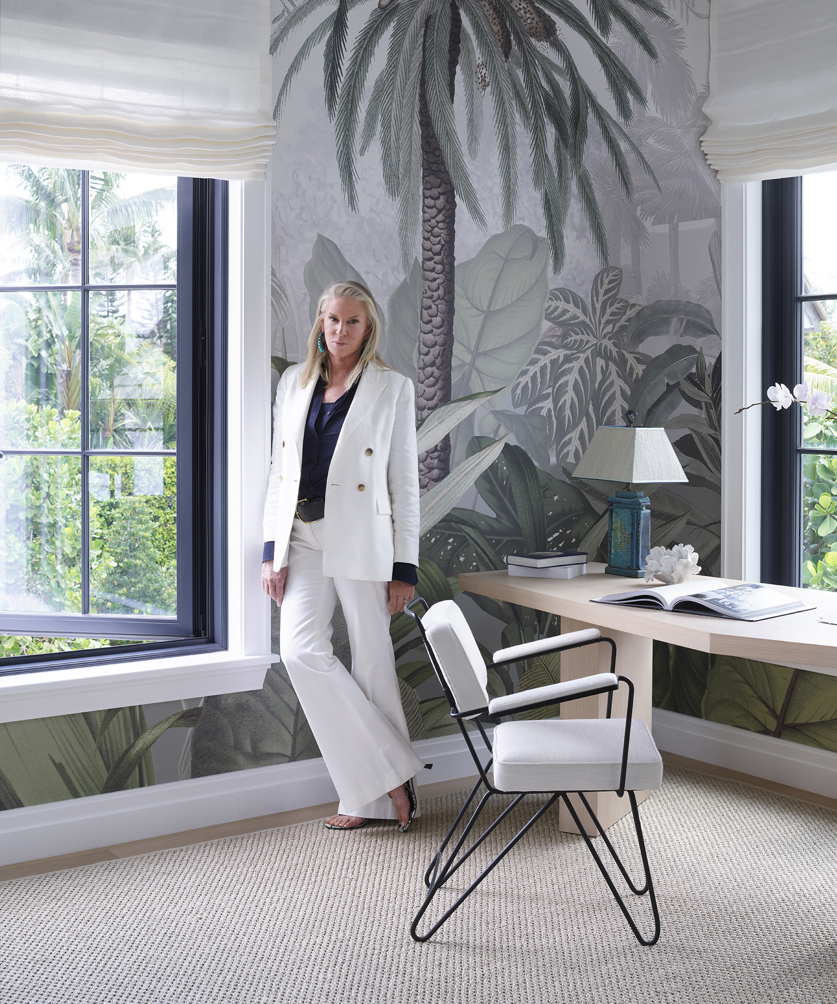 Victoria Hagan standing in a large office next to a mural of a palm tree