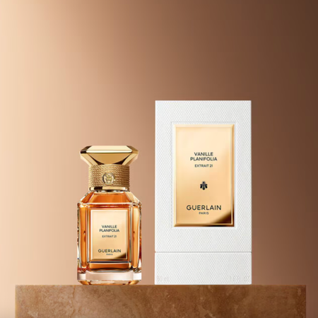 Guerlain Vanille Planifolia perfume. The perfume is in a clear bottle with a textured gold cap. 