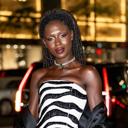 a black woman with locs wearing a zebra print, strapless dress