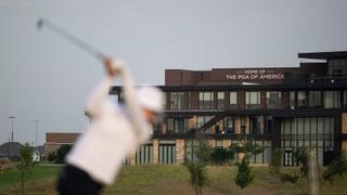 Blurred golfer in the foreground and PGA of America building in the background