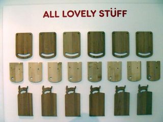 Different designs of wooden shop boards hanging on a white wall, with the text ALL LOVELY STUFF written above in red