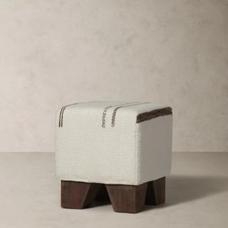 A white and brown ottoman from Banana Republic