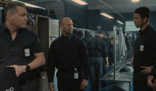 Holt McCallany, Jason Statham, and Josh Hartnett talking in the locker room in Wrath of Man.