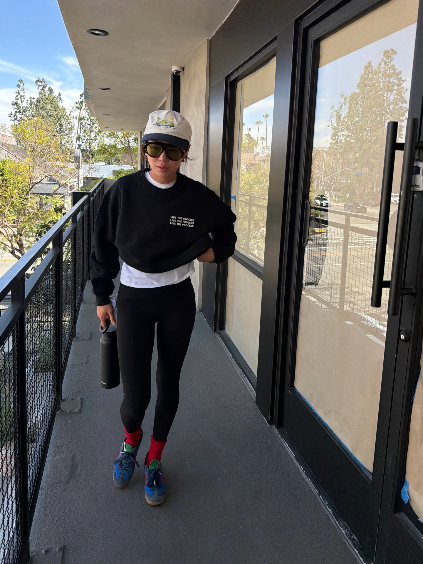 Aimee Song wearing a green and white baseball cap and leggings.