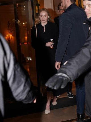 Sophie Turner in Paris wearing a black coat and tan Manolo Blahnik Maysale heels.