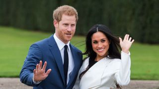 Prince Harry and Meghan Markle, wearing a white belted coat by Canadian brand Line The Label, attend a photocall in the Sunken Gardens at Kensington Palace