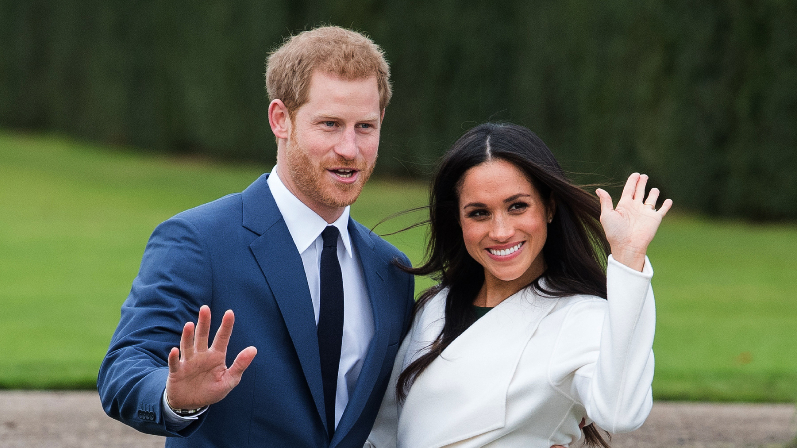 Princ Harry a Meghan Markle v bílém kabátu s páskem od kanadské značky Line The Label se účastní fotohovoru v Sunken Gardens v Kensingtonském paláci.