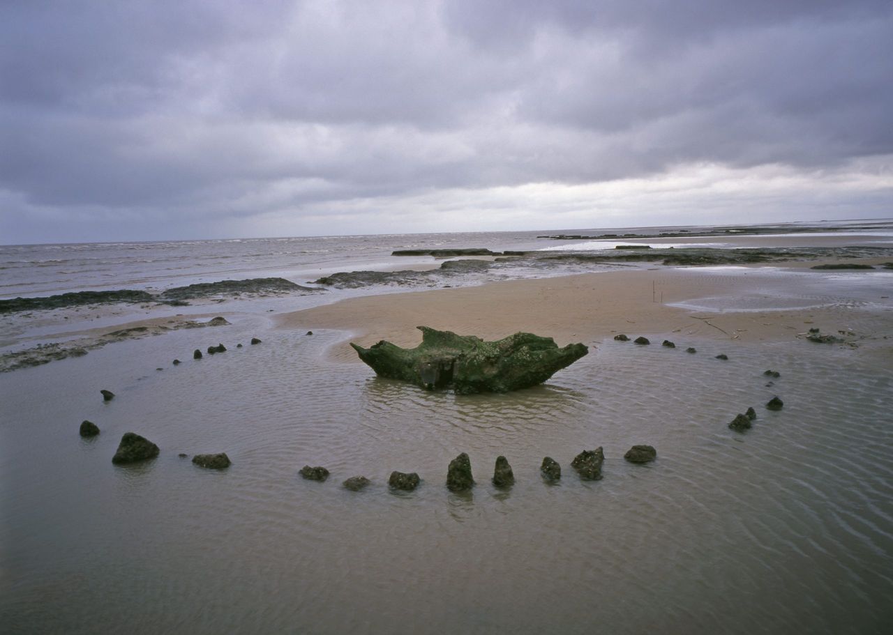 The sacred 4000 year old site of Seahenge exposed briefly by the shifting sands on the Norfolk coast near Hunstanton.