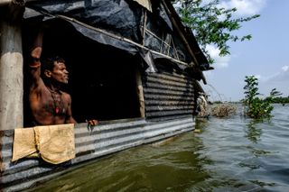 Dipayan Bose captured this striking image of a villager, again in the Sundarbans, standing inside his half submerged home during a flood