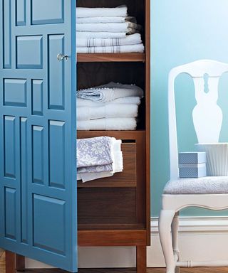 blue linen closet and white chair
