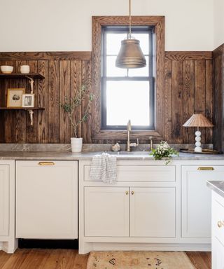 neutral kitchen with wood clad upper wall, white cabinets, rustic decor