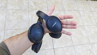 Bose QC Headphones and QC45 handing off the arm of the reviewer