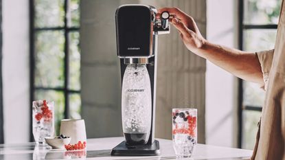 One of the SodaStreams on sale this Black Friday, the SodaStream Art on a countertop making sparkling water