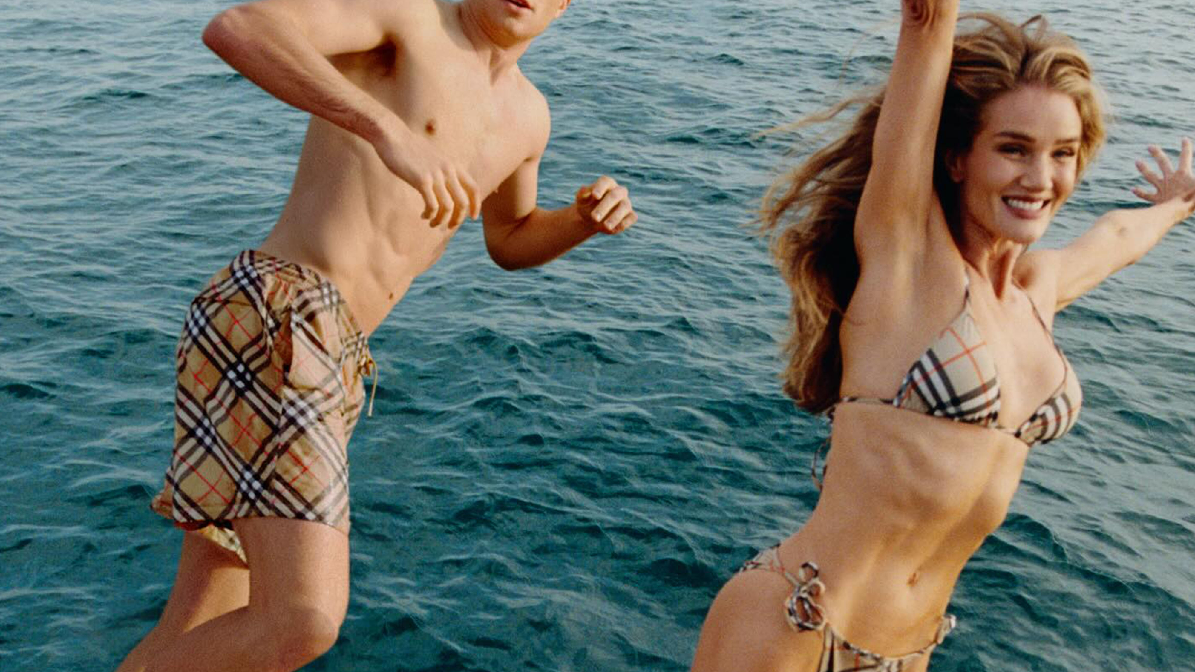 Two models wearing Burberry swimsuits.