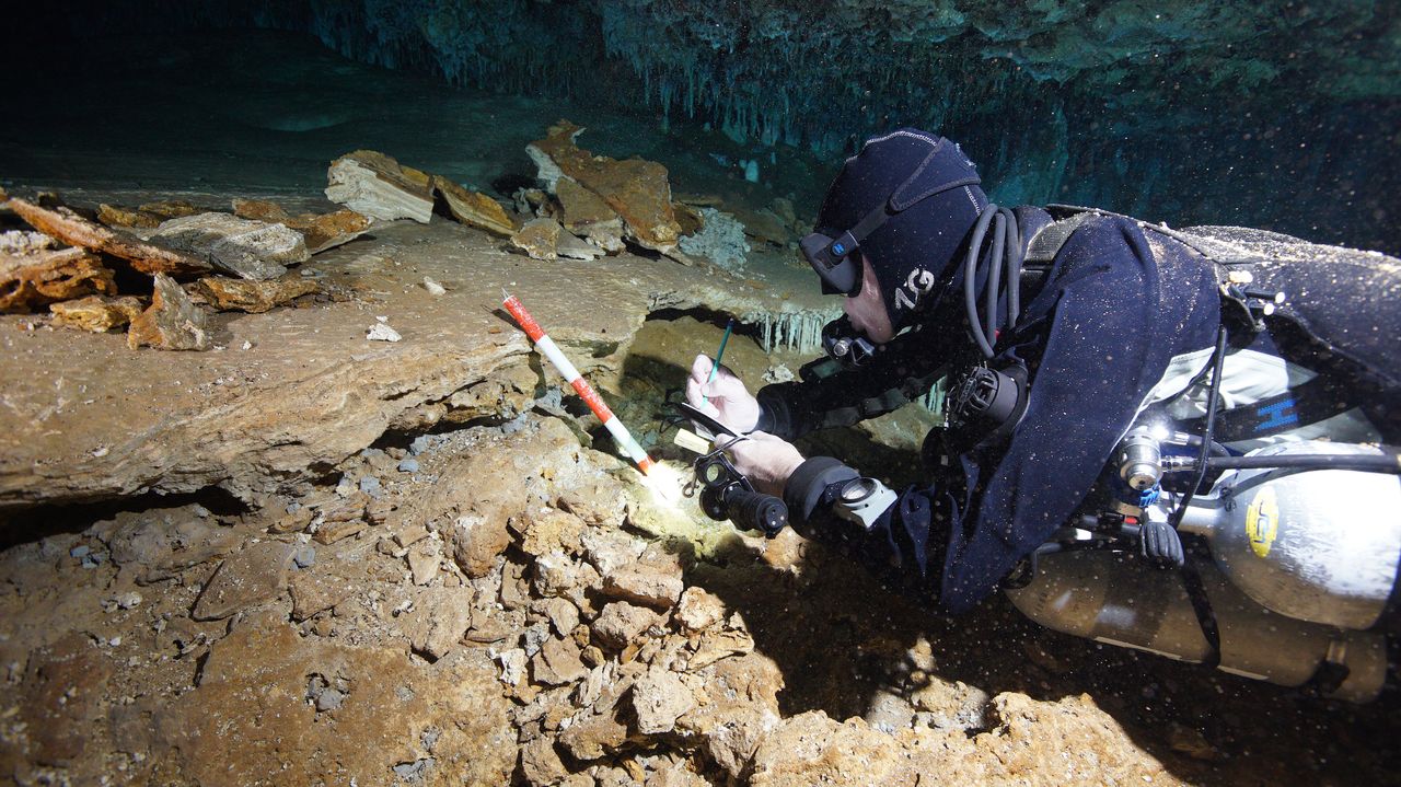 A cave diver examines an ochre extraction pit in the ancient mine.