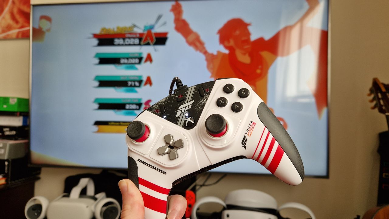 Thrustmaster eSwap XR Pro Controller being held up in front of a TV that's playing Hi-Fi Rush
