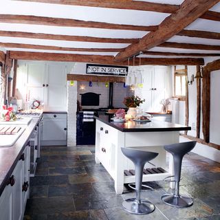 kitchen area with white wall and kitchen units and wooden beam ceiling
