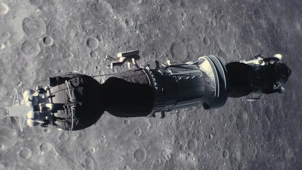 an astronaut climbs along the outside of a cylindrical spacecraft above the moon