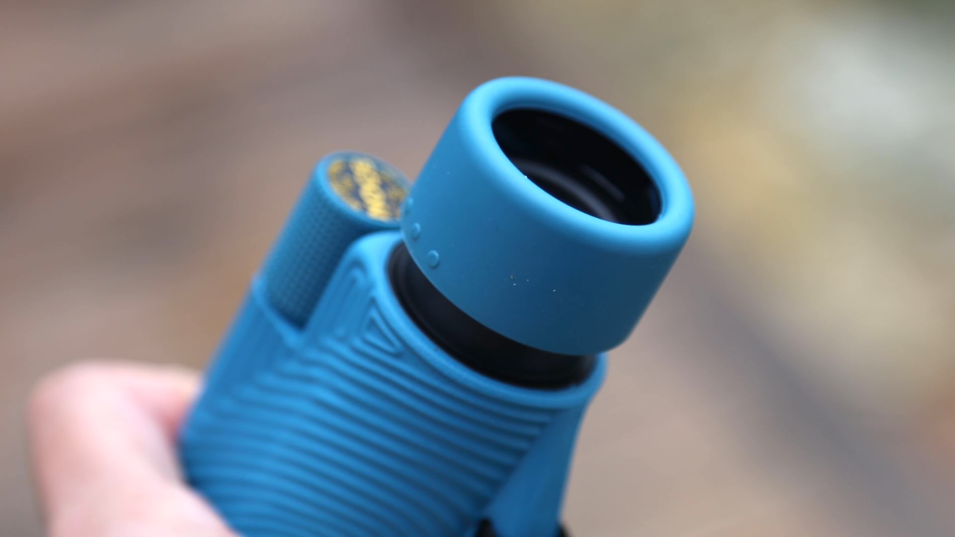 A blue monocular being held.