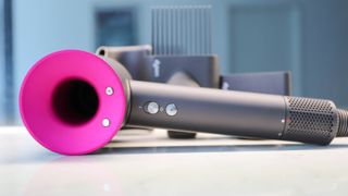 Dyson Supersonic hair dryer with attachments on countertop