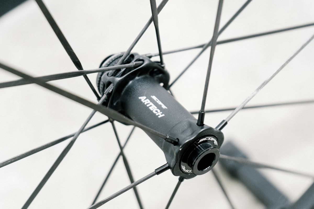 An aero road wheel stands against a white wall