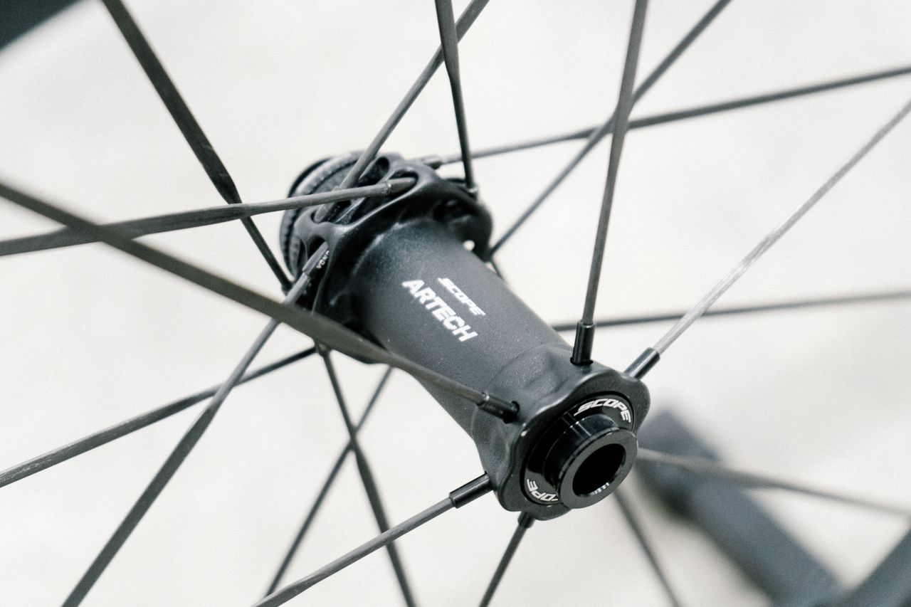 An aero road wheel stands against a white wall