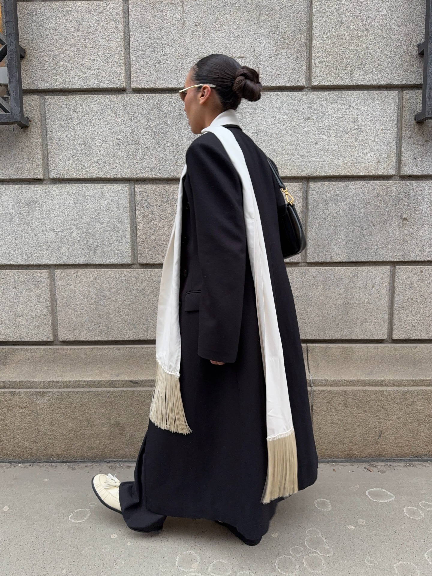 Woman in coat and fringe scarf.