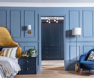 Light blue bedroom, dark blue bedside table and cabinets, gold bedframe